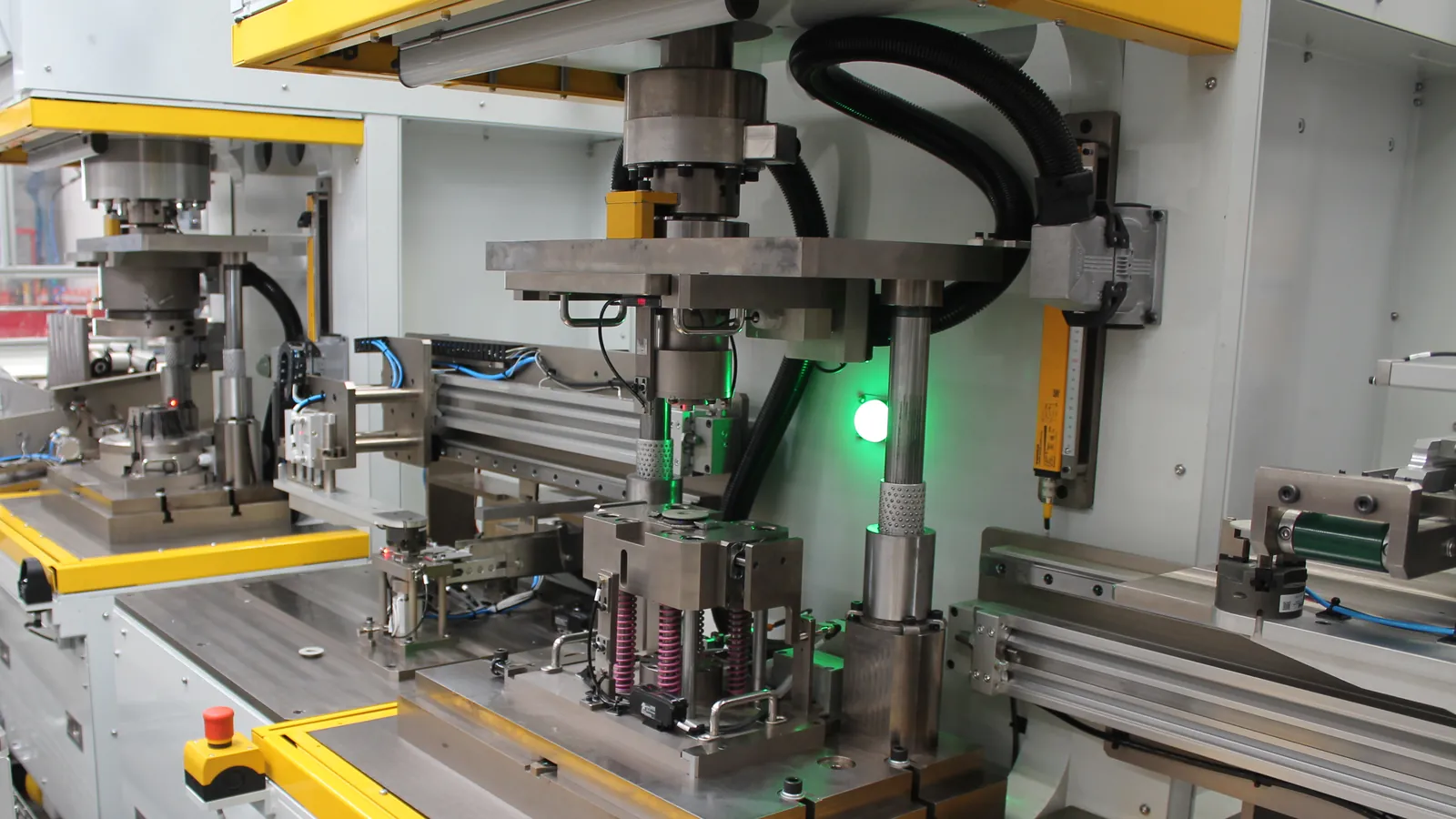 Press station with a guided press head over a part nest on die springs and transfer slides, built by AMD Machines