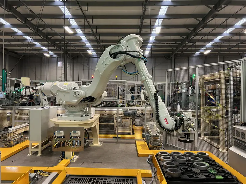 Large ABB robot moving parts between trays in a material handling cell built by AMD Machines