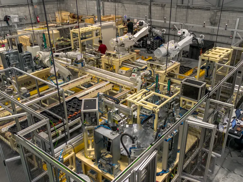 Overhead view of a large automated assembly line with ABB robots, built by AMD Machines