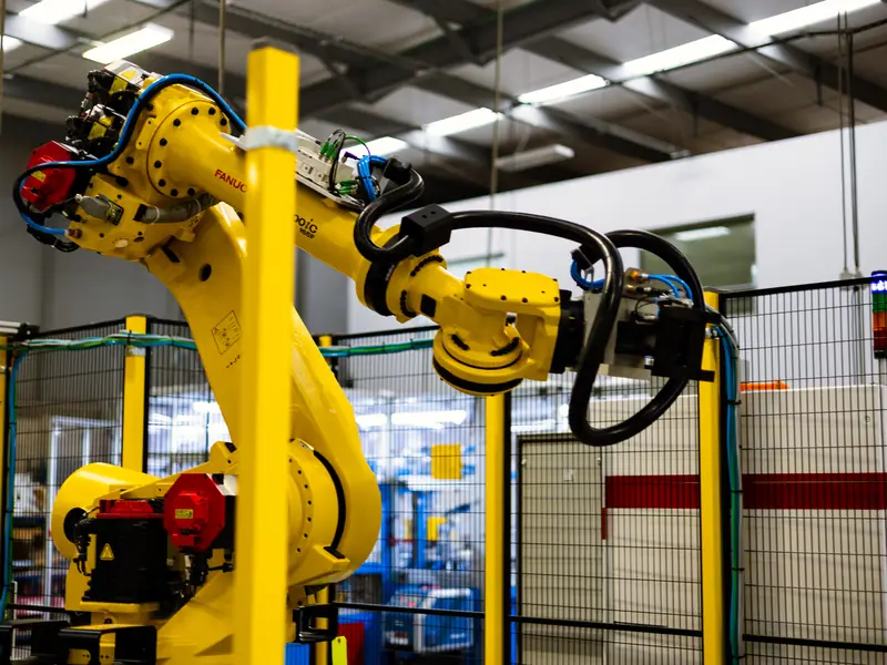 FANUC industrial robot inside a guarded robotic cell at AMD Machines
