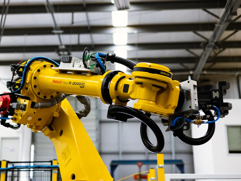 FANUC R-2000iC/165F high-payload robot with a gripper end-of-arm tool in a cell built by AMD Machines