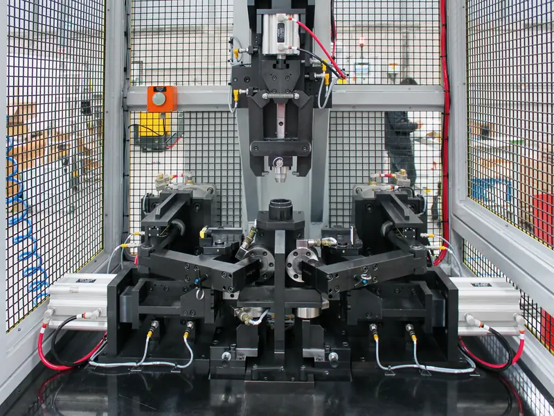 Press station with a custom fixture and clamps inside a guarded cell