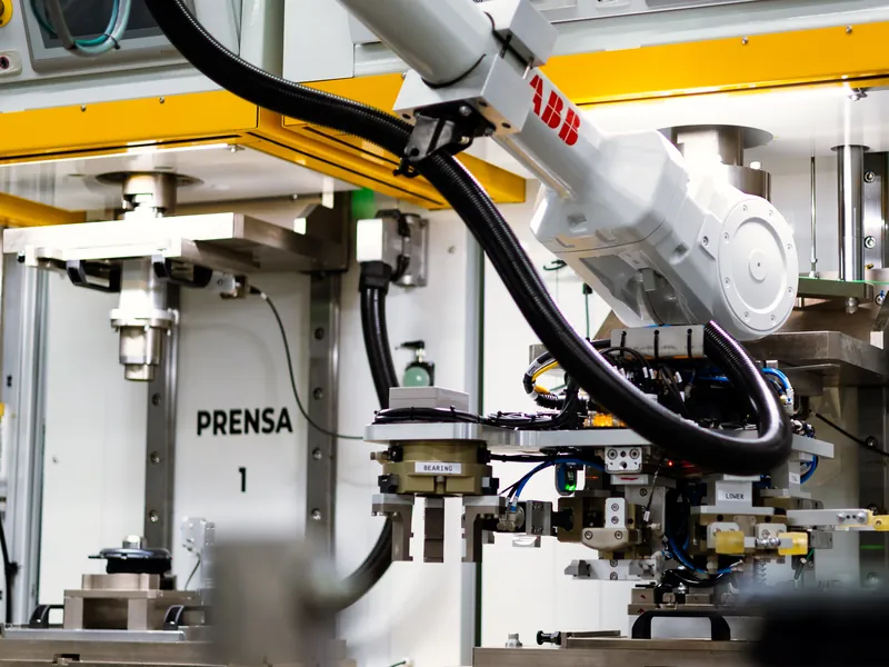 ABB robot with a multi-gripper end-of-arm tool loading press station 1 on an assembly line, built by AMD Machines